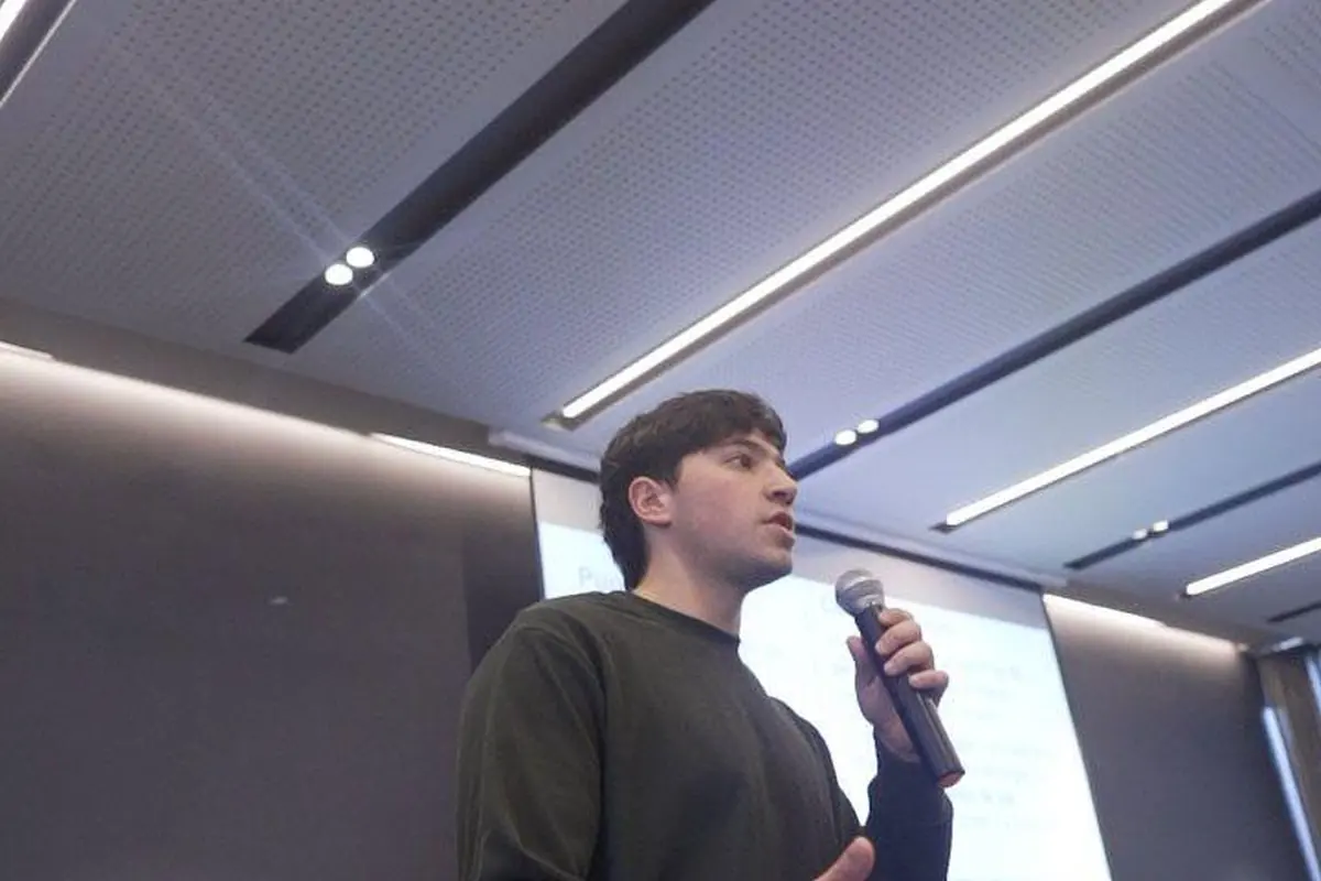 Integrante de Aithor dictando una instancia en vivo con micrófono en una sala de reuniones