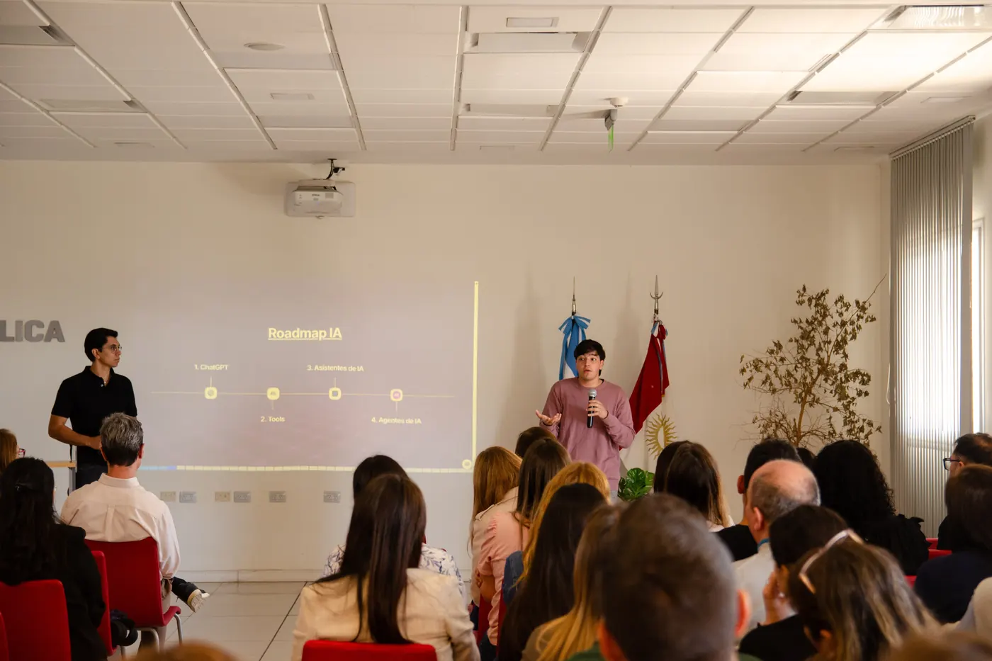 Charla de Aithor frente a una lámina con el roadmap de adopción de IA de una organización