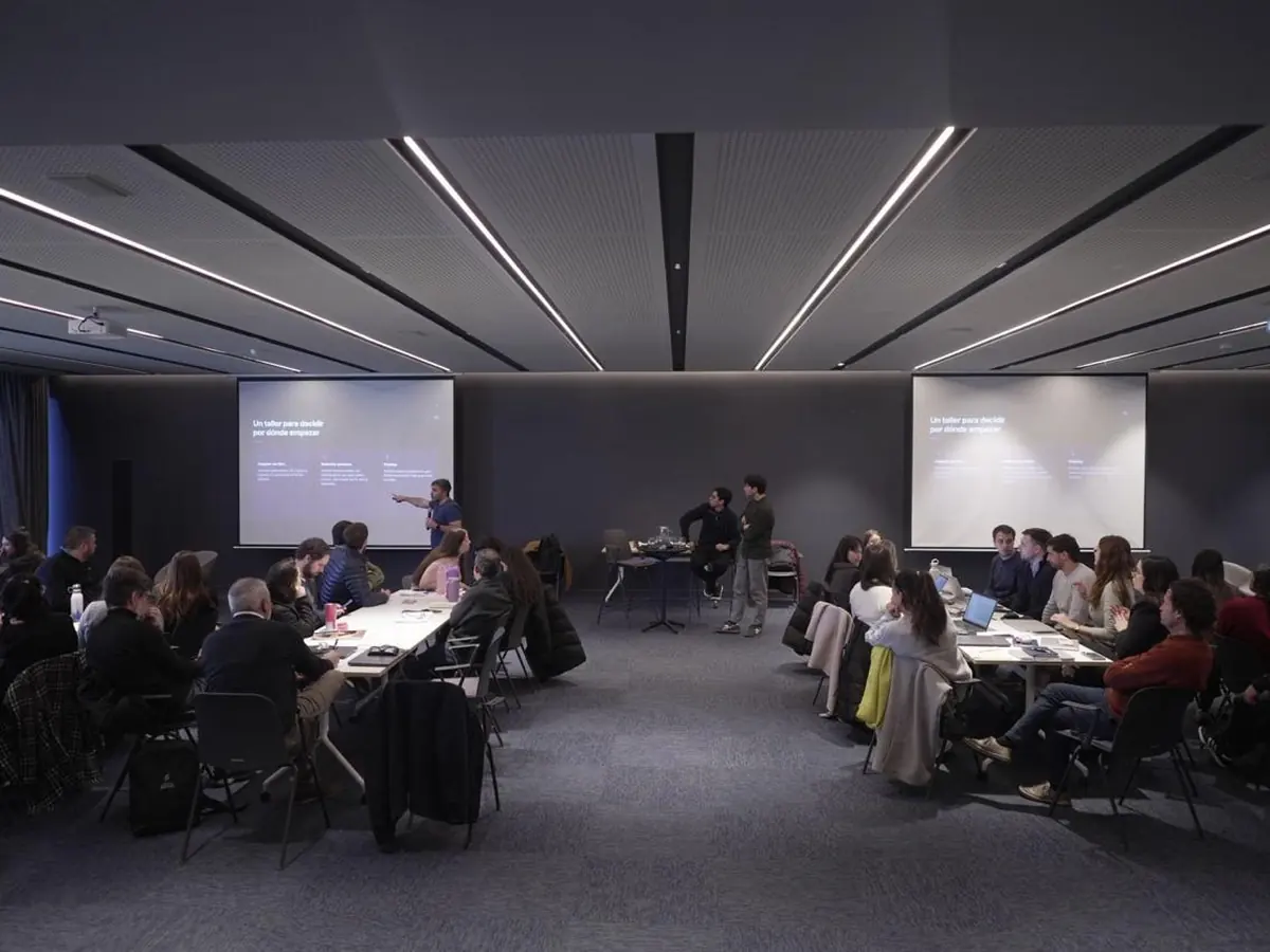 Sala de capacitación con los equipos de una empresa trabajando en mesas