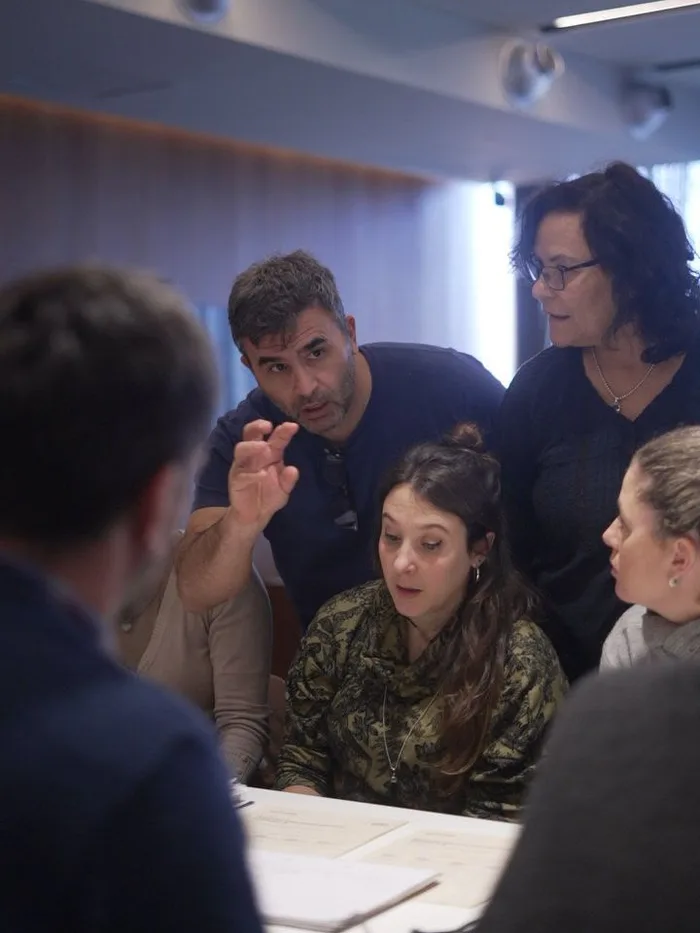 Conversación en una mesa de trabajo durante un taller de rediseño de flujos